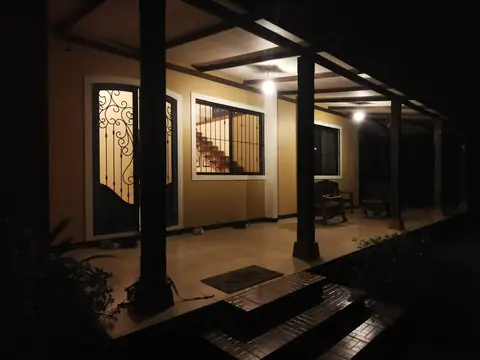 The lit veranda in the evening — Main house, Rio Ángel Bio-reserve