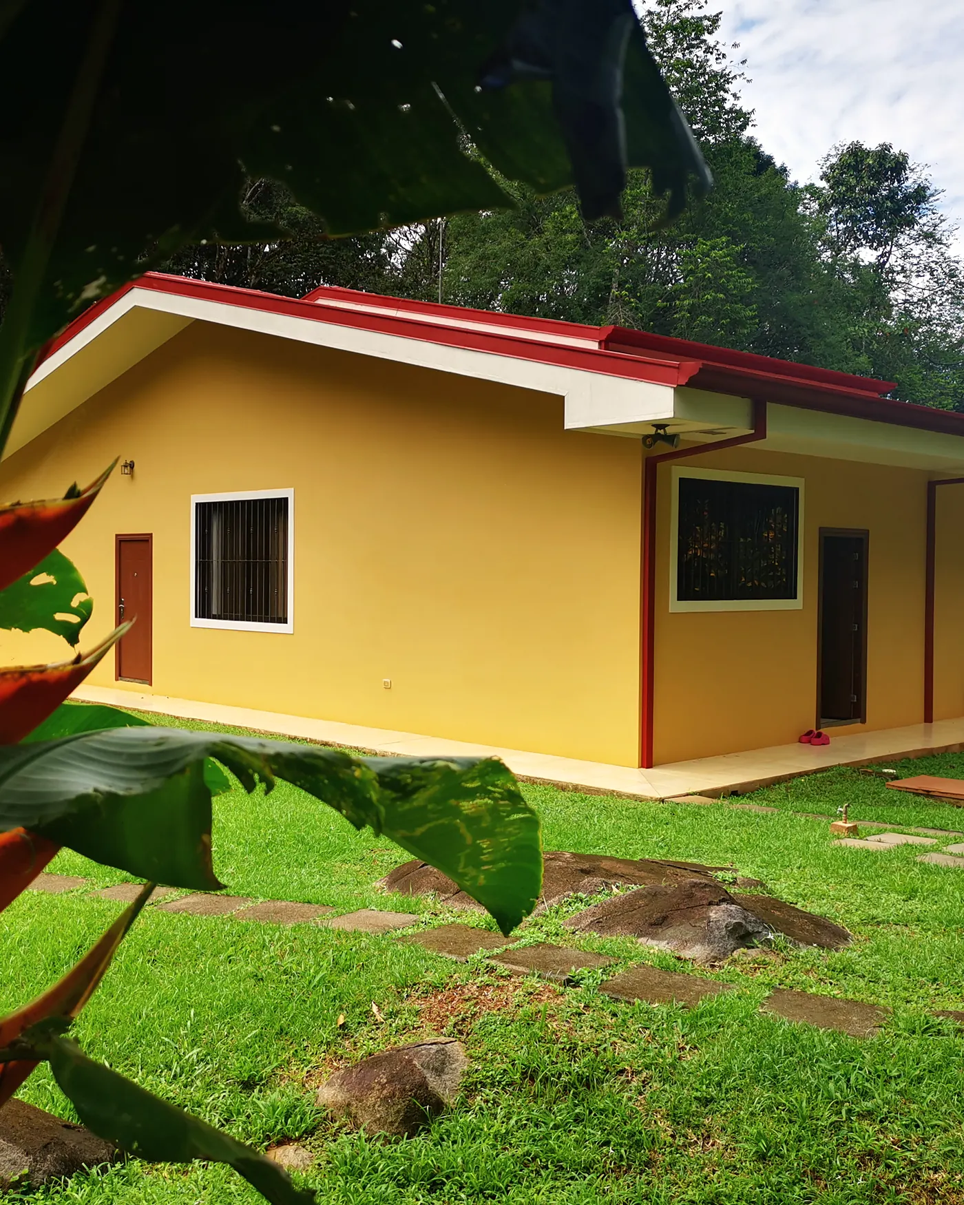 The house framed by a heliconia flower