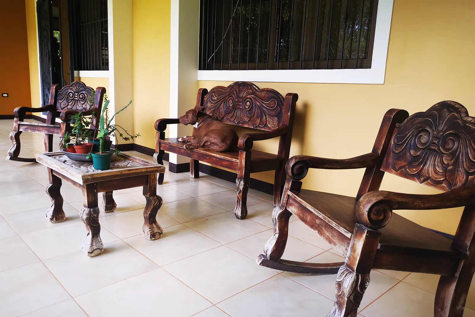 The covered veranda of the main house with wooden furniture